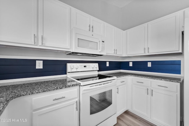 kitchen featuring dark stone counters, white cabinetry, white appliances, and light wood-style flooring