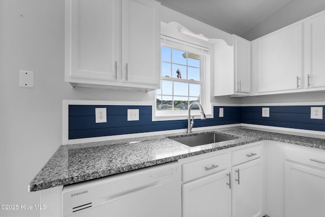 kitchen featuring dishwasher, white cabinetry, a sink, and stone counters