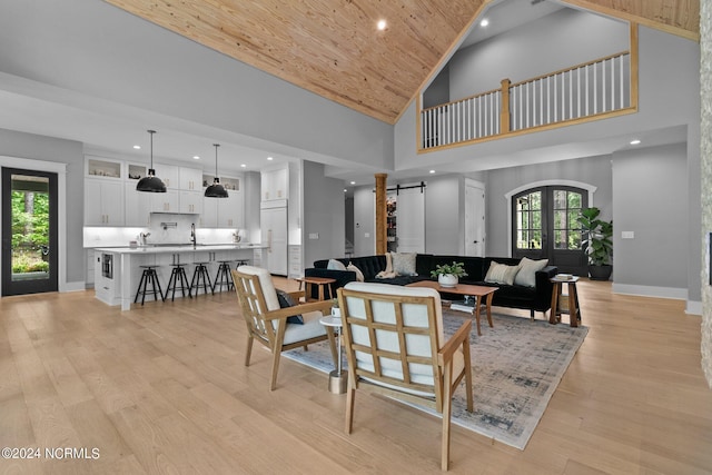 living area featuring french doors, baseboards, light wood-style floors, wooden ceiling, and high vaulted ceiling