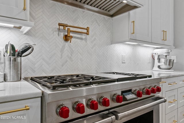 kitchen featuring backsplash, custom exhaust hood, high end stainless steel range oven, and white cabinetry