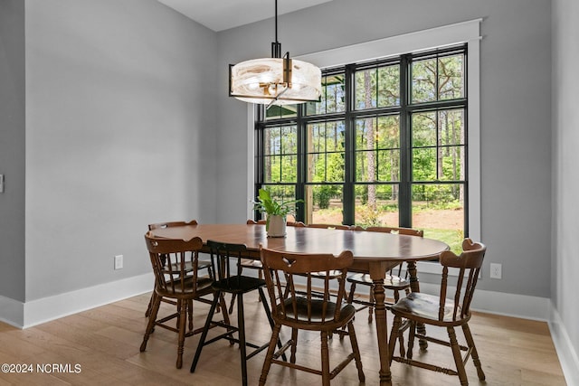 dining space with light wood finished floors and baseboards