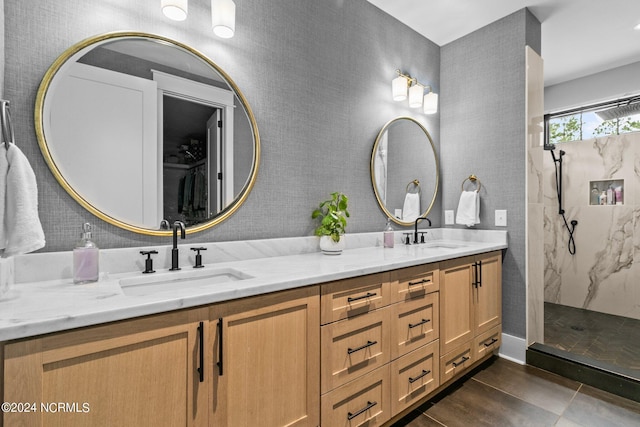 full bathroom featuring a marble finish shower, a sink, and double vanity
