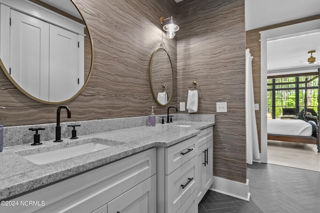 ensuite bathroom featuring tile patterned floors, ensuite bathroom, a sink, and double vanity
