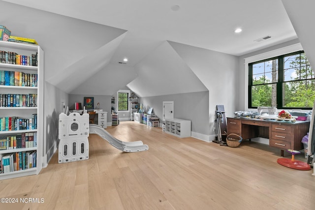 office space with visible vents, baseboards, wood finished floors, and lofted ceiling