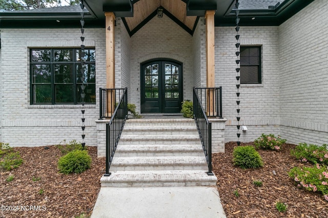 property entrance featuring brick siding and french doors