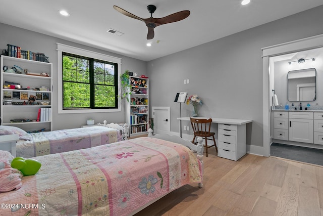bedroom featuring ensuite bathroom, a sink, light wood-style floors, visible vents, and recessed lighting