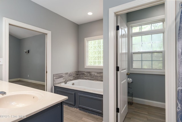 6321 Albatross Dr, New Bern, NC 28560 - bathroom with a garden tub, wood finished floors, vanity, and baseboards