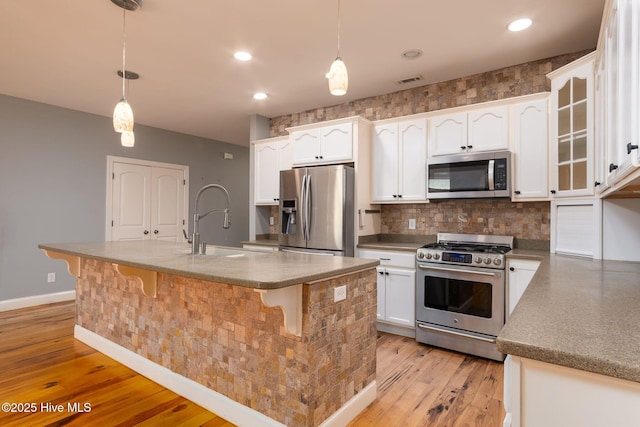 6321 Albatross Dr, New Bern, NC 28560 - kitchen featuring stainless steel appliances, a sink, white cabinets, light wood finished floors, and recessed lighting