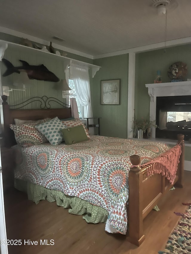 42 Brite Ln, Oriental, NC 28571 - bedroom featuring wood finished floors, visible vents, ornamental molding, and a multi sided fireplace