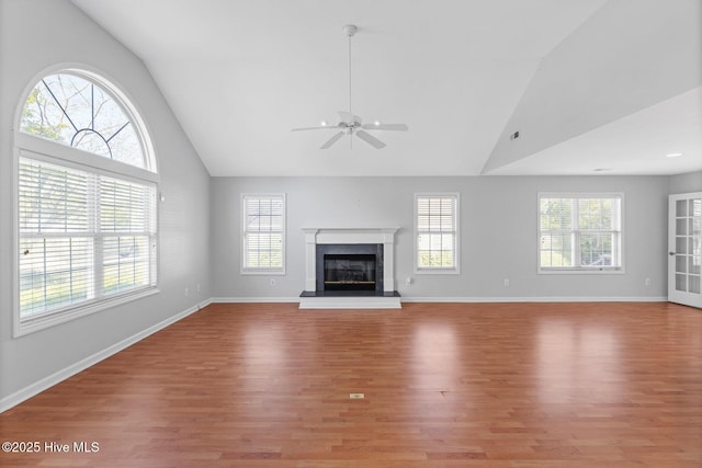 unfurnished living room featuring high vaulted ceiling, light wood-style flooring, and a ceiling fan