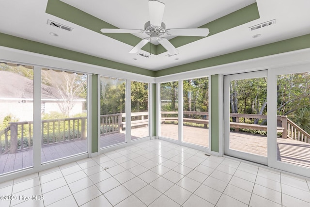 unfurnished sunroom featuring tile patterned flooring, visible vents, and ceiling fan