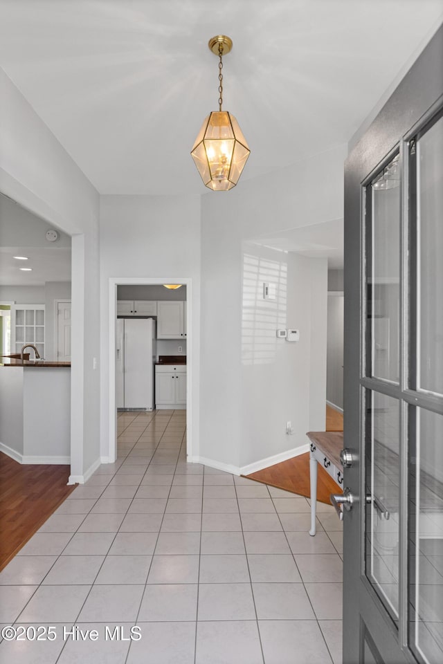 interior space featuring light tile patterned floors and baseboards