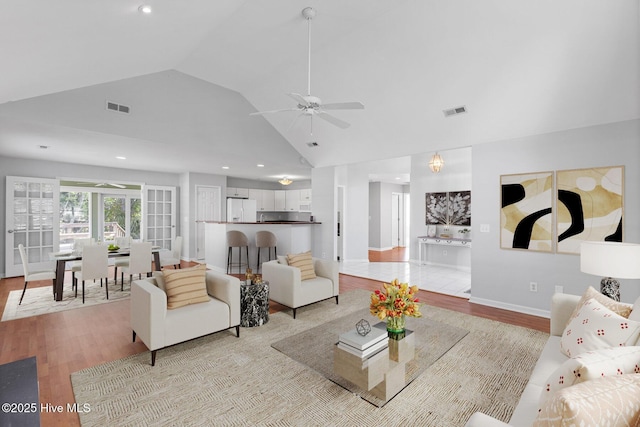 living room with light wood-style flooring, visible vents, and ceiling fan