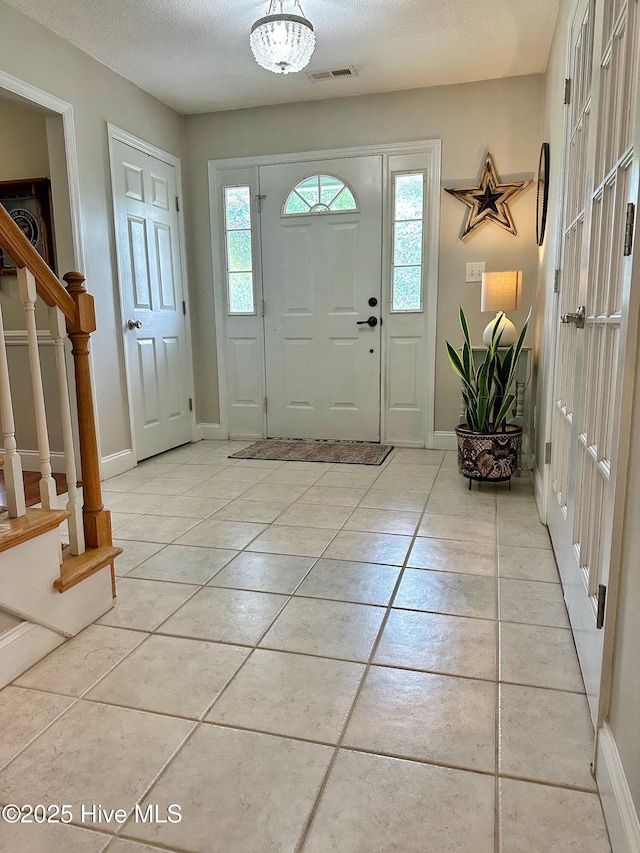 entrance foyer with baseboards, a wealth of natural light, and visible vents