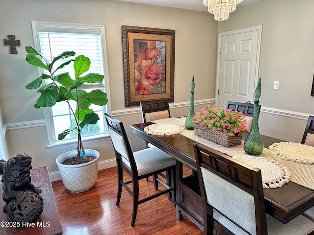 dining space with a wealth of natural light, wood finished floors, and a notable chandelier