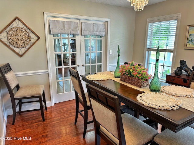 dining room with french doors, dark wood-style floors, and a chandelier