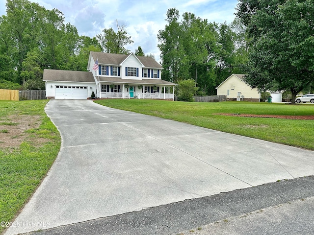 colonial house with fence, covered porch, a front yard, an attached garage, and driveway