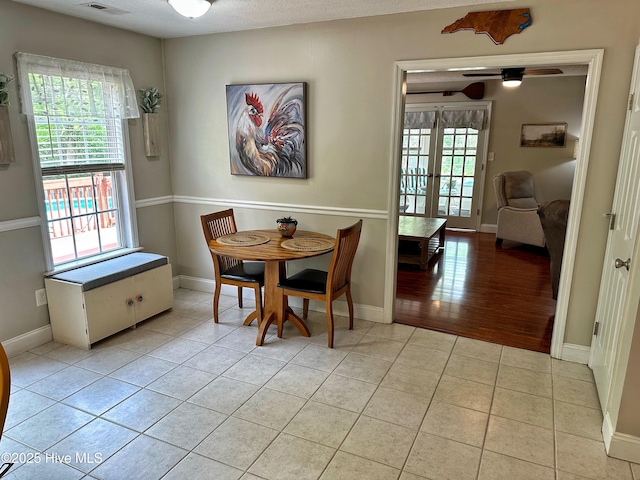 dining area featuring a ceiling fan, baseboards, and light tile patterned floors