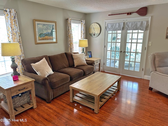 living room with french doors, a textured ceiling, and wood finished floors