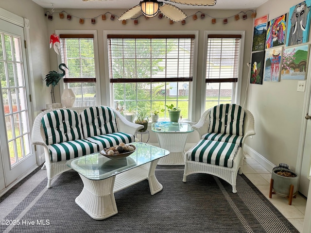 living area featuring tile patterned floors, baseboards, and a ceiling fan
