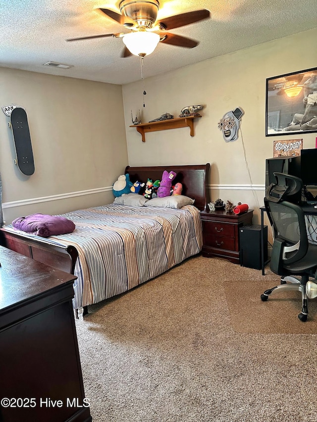 carpeted bedroom featuring a ceiling fan, a textured ceiling, and visible vents