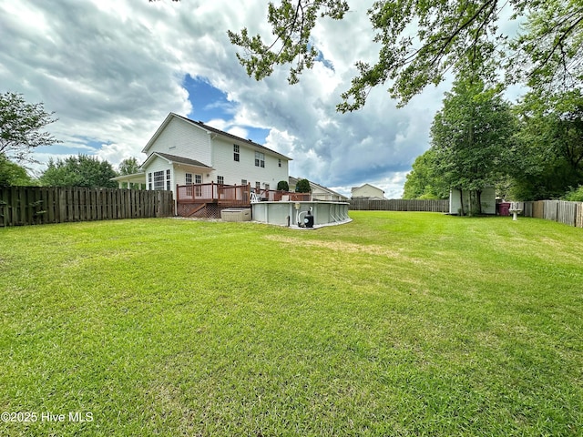 view of yard featuring a storage unit, a wooden deck, a fenced backyard, a swimming pool, and an outdoor structure