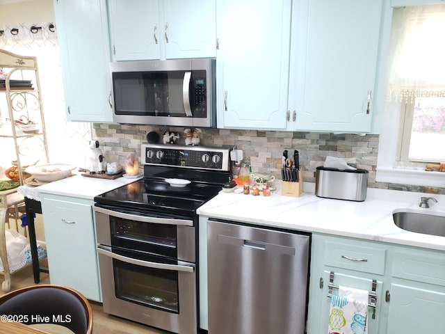 504 E S St, Fremont, NC 27830 - kitchen featuring appliances with stainless steel finishes, a sink, tasteful backsplash, and white cabinets