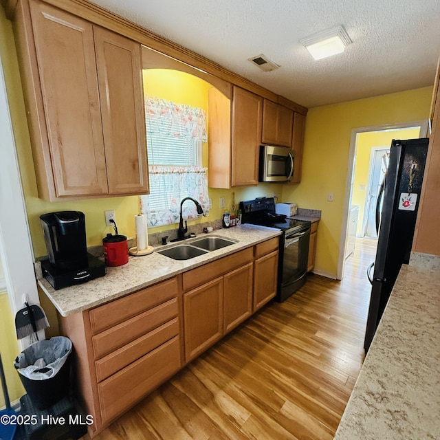 501 Blackfoot Trl, Edenton, NC 27932 - kitchen featuring a textured ceiling, a sink, black appliances, light wood-style flooring, and visible vents