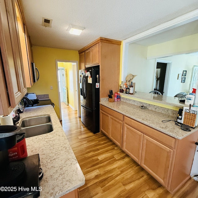 501 Blackfoot Trl, Edenton, NC 27932 - kitchen with a sink, stainless steel microwave, light wood-type flooring, black fridge with ice dispenser, and electric range oven