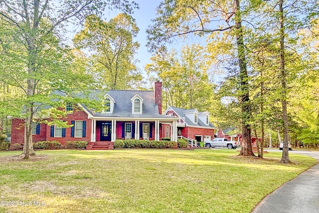 cape cod home with a chimney, brick siding, and a front yard
