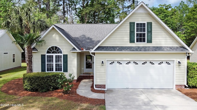 view of front of home with driveway and roof with shingles