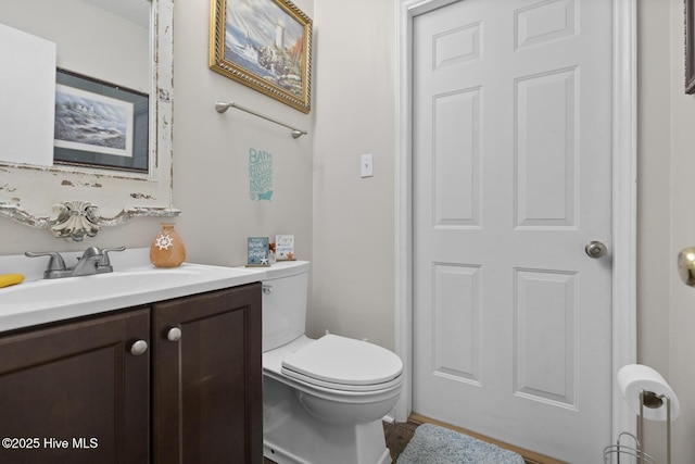 bathroom featuring wood finished floors, toilet, and vanity