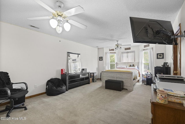 carpeted bedroom with visible vents, a textured ceiling, and ceiling fan