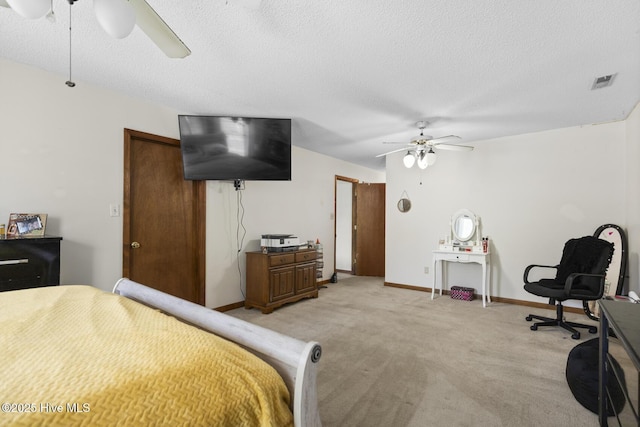 bedroom featuring light carpet, visible vents, and a textured ceiling