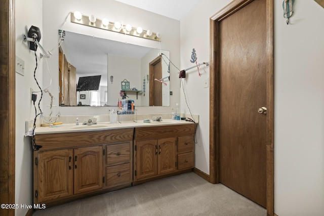 full bathroom featuring baseboards, a sink, and double vanity