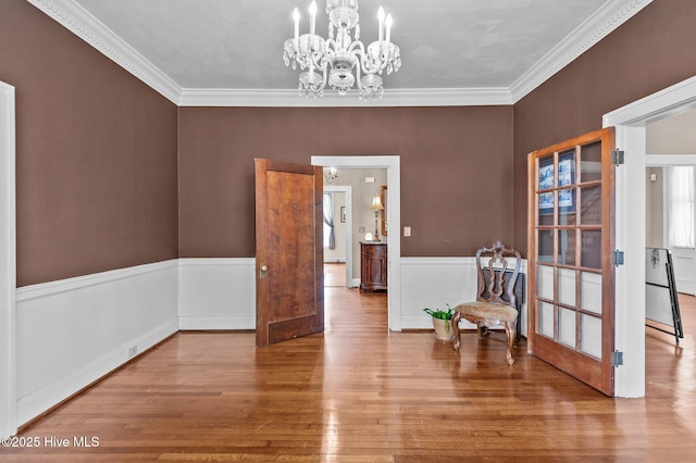 306 N Parker St, Elm City, NC 27822 - interior space with crown molding, a notable chandelier, a wainscoted wall, and wood finished floors