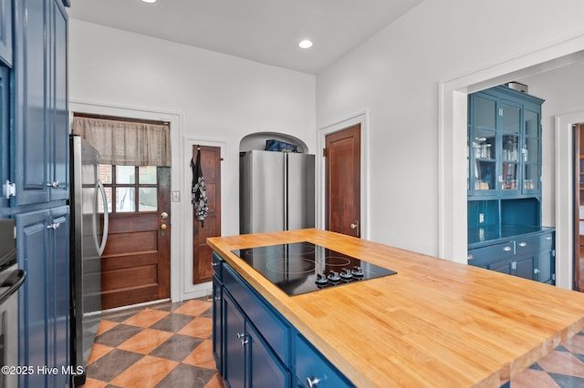 306 N Parker St, Elm City, NC 27822 - kitchen featuring butcher block counters, freestanding refrigerator, black electric stovetop, and blue cabinetry