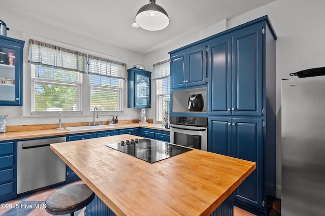 306 N Parker St, Elm City, NC 27822 - kitchen with a sink, blue cabinets, a breakfast bar area, butcher block counters, and stainless steel appliances