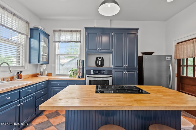 306 N Parker St, Elm City, NC 27822 - kitchen featuring stainless steel appliances, a sink, blue cabinetry, a breakfast bar, and wooden counters