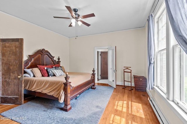 306 N Parker St, Elm City, NC 27822 - bedroom with crown molding, a baseboard heating unit, ceiling fan, light wood-style flooring, and baseboards