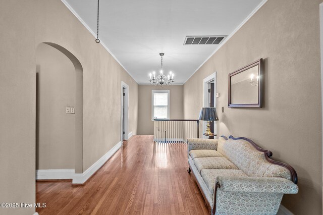 306 N Parker St, Elm City, NC 27822 - corridor featuring wood finished floors, ornamental molding, arched walkways, a notable chandelier, and visible vents
