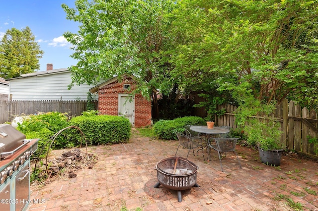 306 N Parker St, Elm City, NC 27822 - view of patio / terrace featuring a shed, a fenced backyard, an outdoor structure, a fire pit, and outdoor dining area