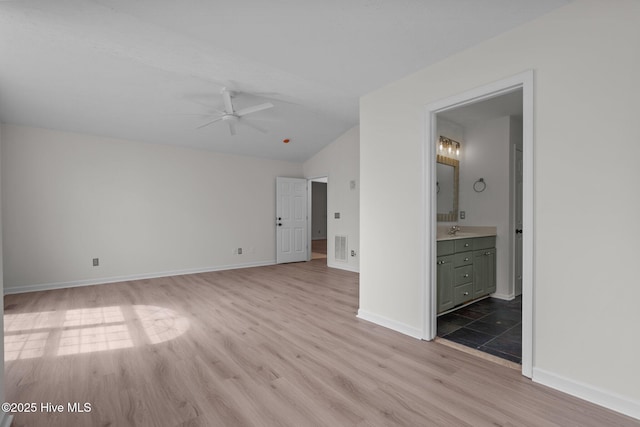 155 Patricia Ct, Whispering Pines, NC 28327 - unfurnished living room featuring light wood-type flooring, ceiling fan, lofted ceiling, baseboards, and a sink