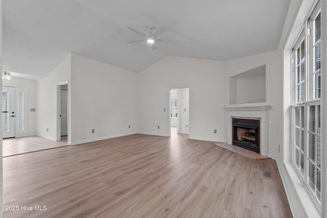 155 Patricia Ct, Whispering Pines, NC 28327 - unfurnished living room with ceiling fan, vaulted ceiling, light wood-style floors, a fireplace with flush hearth, and baseboards