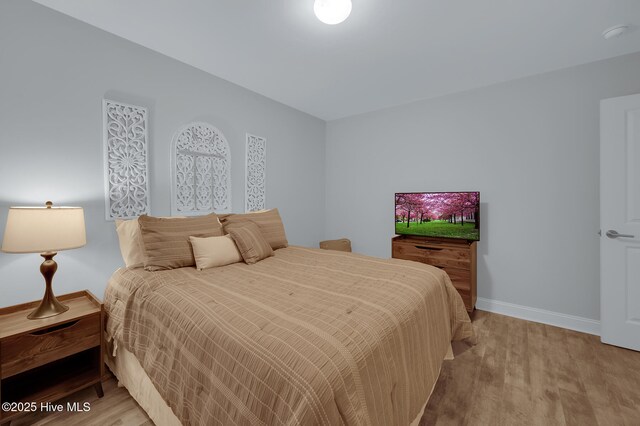 bedroom with baseboards and light wood-style flooring