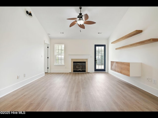 711 Glenarthur Dr, Wilmington, NC 28412 - unfurnished living room featuring a ceiling fan, light wood-style flooring, a glass covered fireplace, baseboards, and lofted ceiling