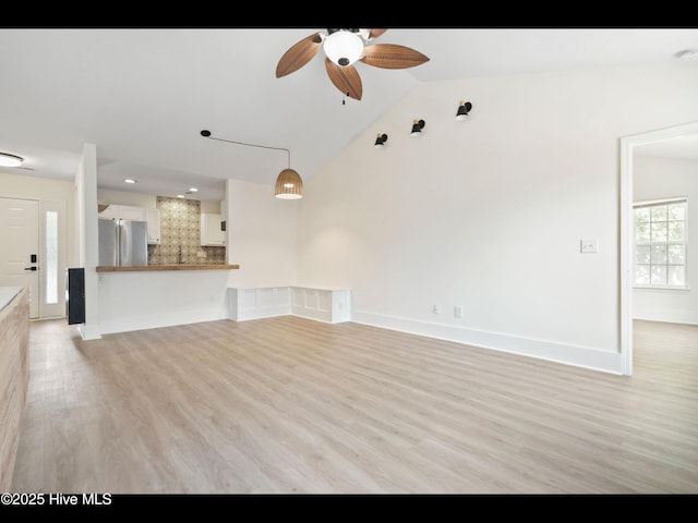 711 Glenarthur Dr, Wilmington, NC 28412 - unfurnished living room with ceiling fan, light wood-style flooring, vaulted ceiling, and baseboards