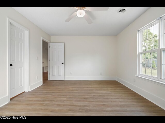 711 Glenarthur Dr, Wilmington, NC 28412 - unfurnished bedroom featuring multiple windows, light wood-style floors, and baseboards