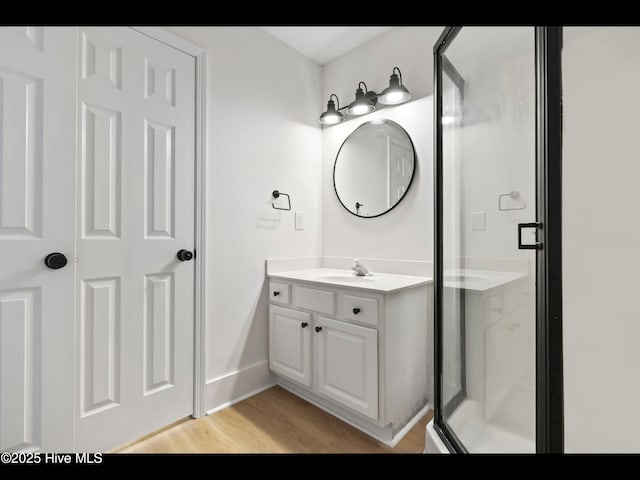 711 Glenarthur Dr, Wilmington, NC 28412 - bathroom with vanity, wood finished floors, a stall shower, and baseboards