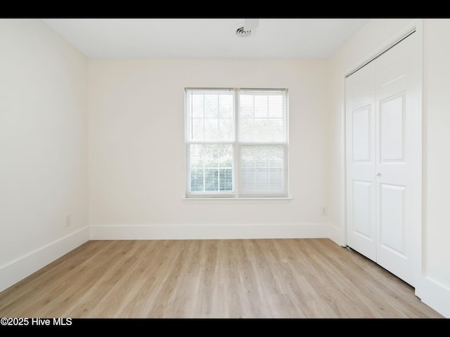 711 Glenarthur Dr, Wilmington, NC 28412 - unfurnished bedroom featuring light wood-style flooring, baseboards, and a closet